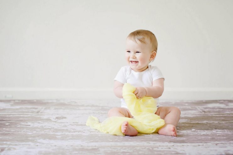 Baby smiling and sitting down.